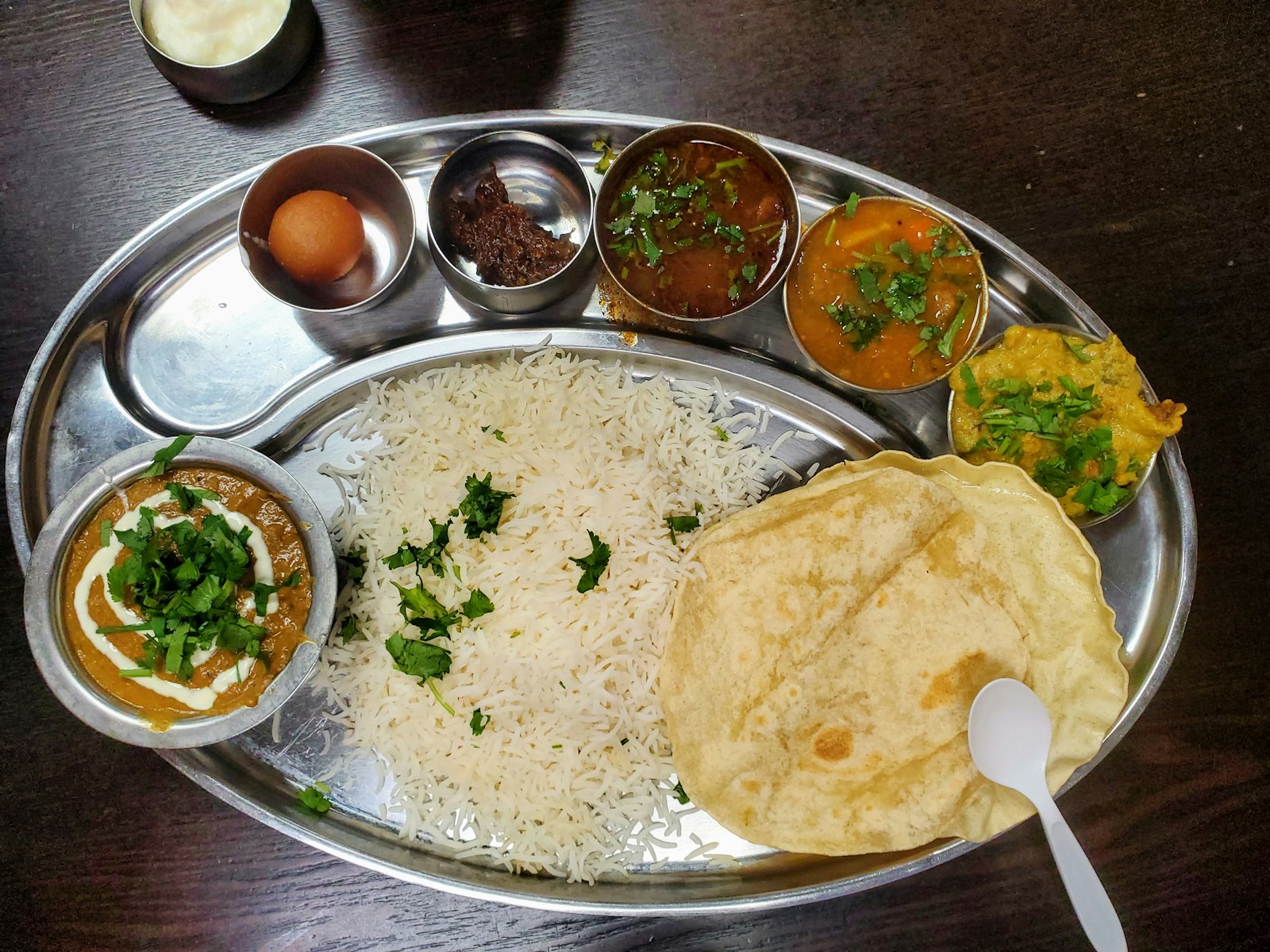 A Punjabi thali set meal with curries, rice, bread and sides